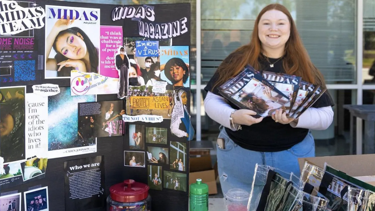 a person holding magazines and a sign