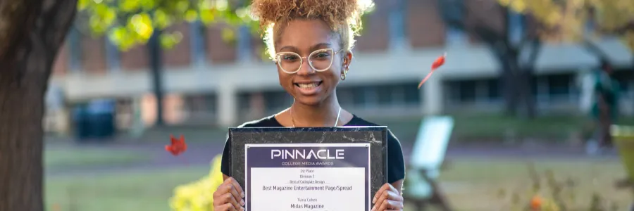 A person holding an award plaque.