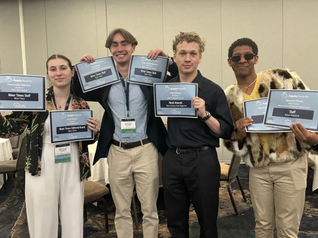 A group of UNC Charlotte students holding awards